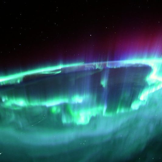 image depicting Astronaut captures amazing view of Earth's green auroras, curious times