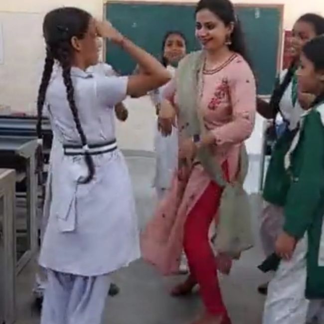 Image depicting teacher dances with students